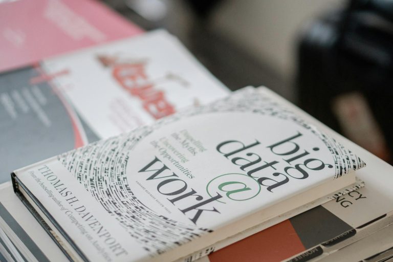 Close-up of books on data analytics and business strategies on a desk.